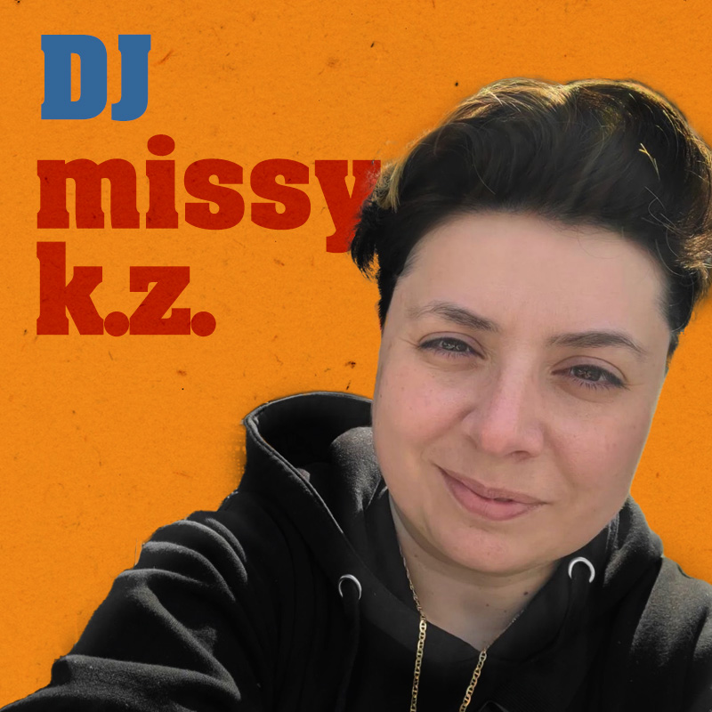 Photo of DJ missy k.z. wearing a black hoodie with smiling with a slightly upturned upper lip